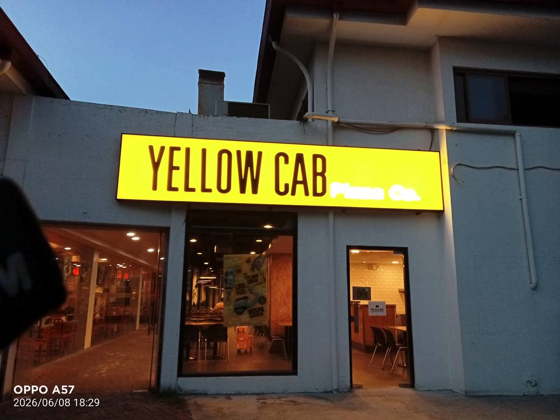Yellow Cab lightbox glowing at dusk after installation